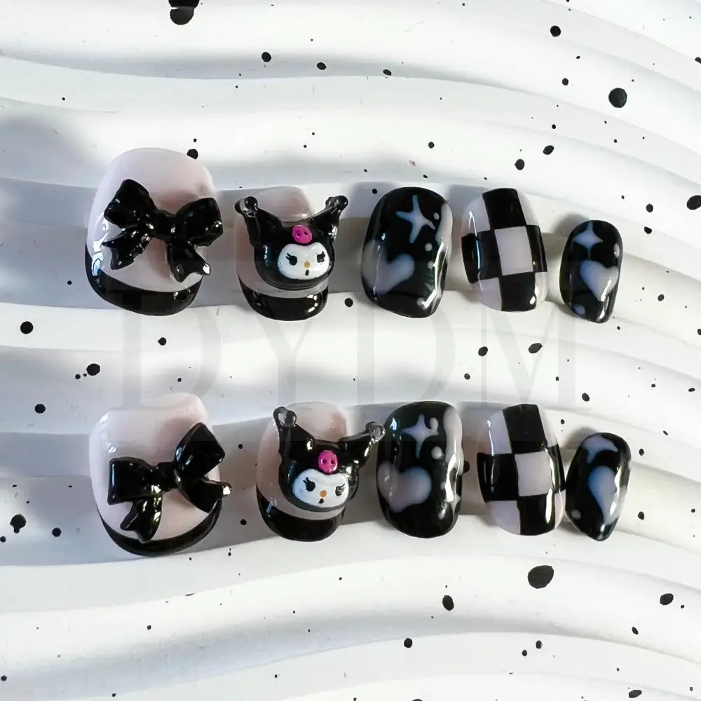Kuromi inspired handmade reusable press on nails featuring a bold black and sweet pink color scheme, adorned with hearts and chess patterns