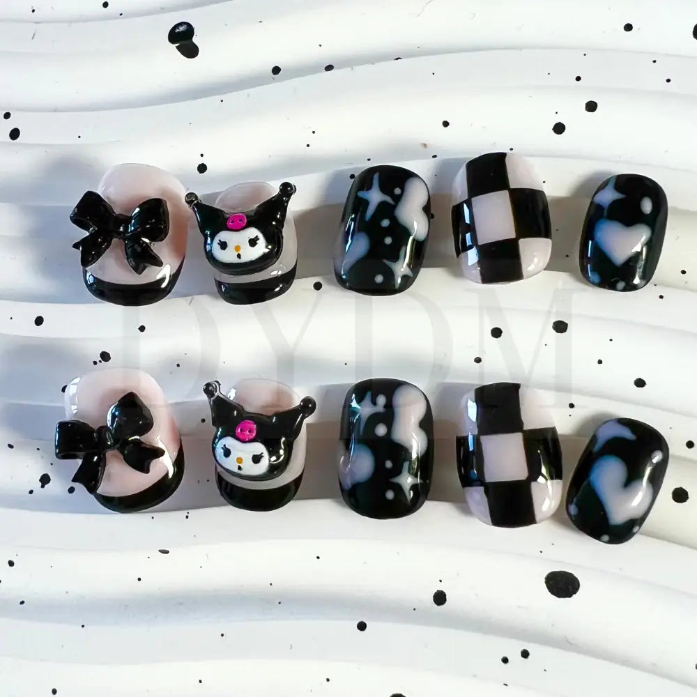 Kuromi inspired handmade reusable press on nails featuring a bold black and sweet pink color scheme, adorned with hearts and chess patterns