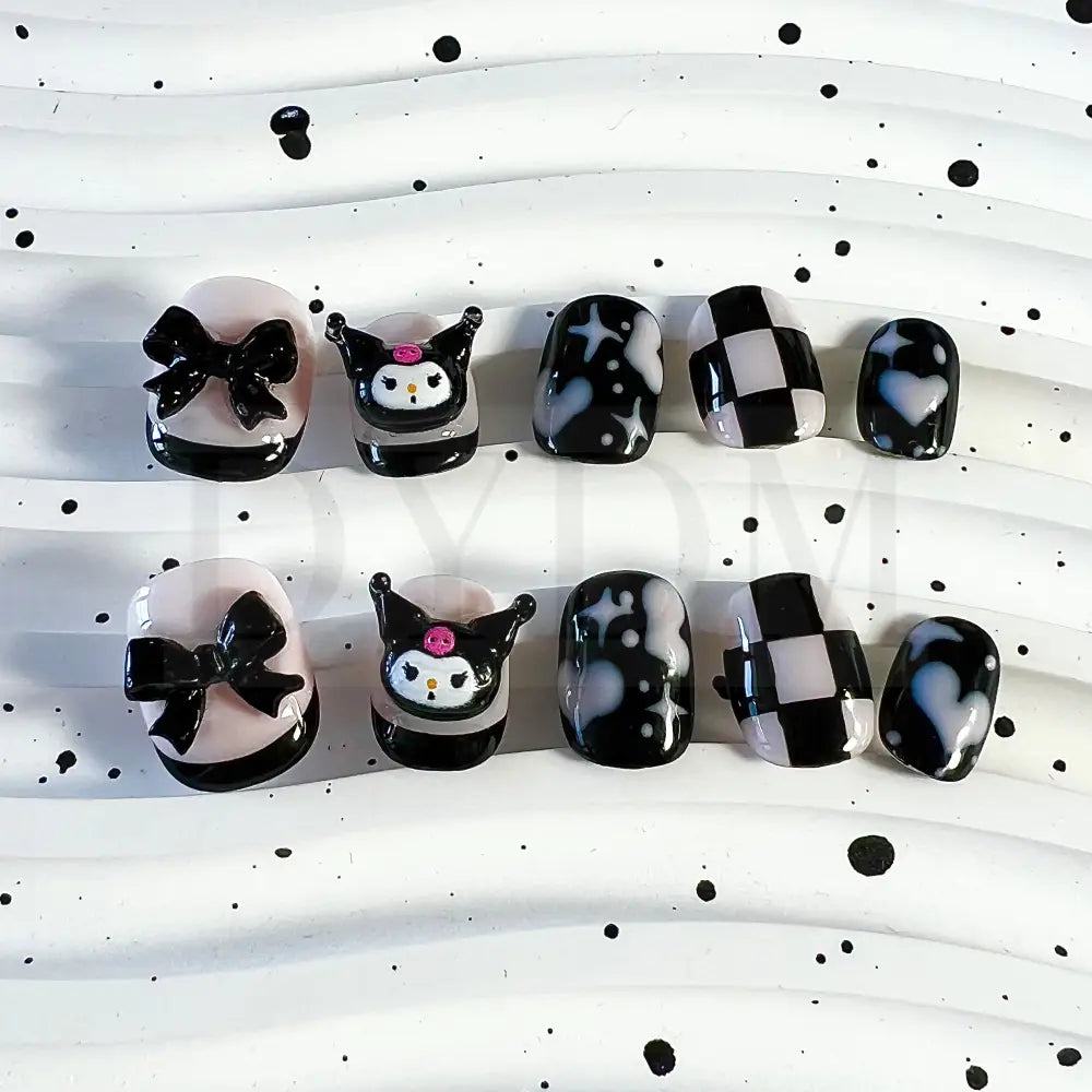 Kuromi inspired handmade reusable press on nails featuring a bold black and sweet pink color scheme,  adorned with hearts and chess patterns