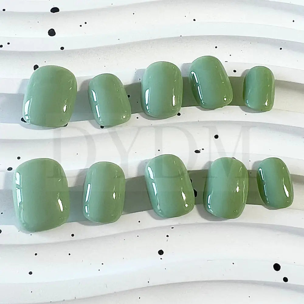 Minty Fresh handpainted press-on nails, featuring a refreshing and vibrant green color reminiscent of a delightful mint macaroon. These nails exude a cool and invigorating essence, adding a touch of vibrancy and sophistication to your fingertips.