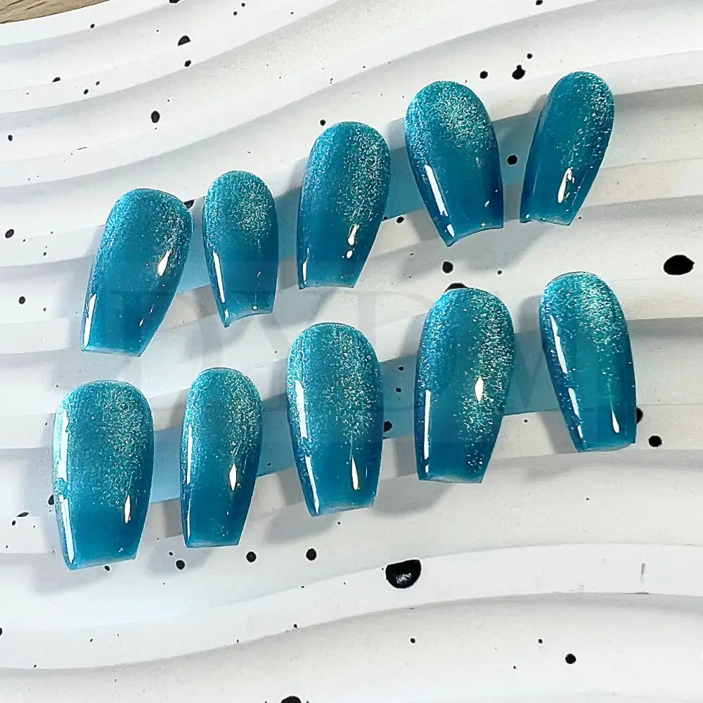 Oceanic Azure handmade press on nails feature a captivating blend of blue and turquoise tones, creating a mesmerizing cat eye effect.