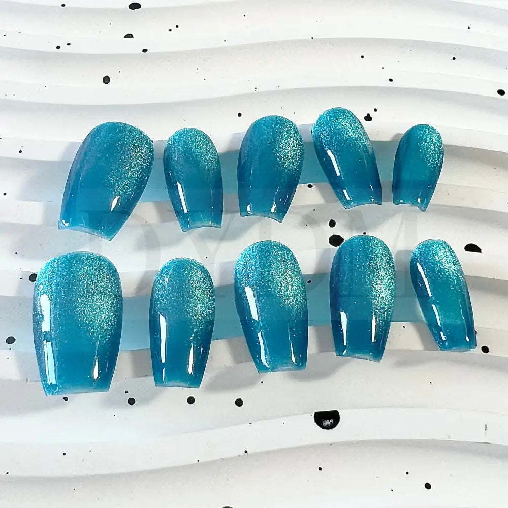 Oceanic Azure handmade press on nails feature a captivating blend of blue and turquoise tones, creating a mesmerizing cat eye effect.