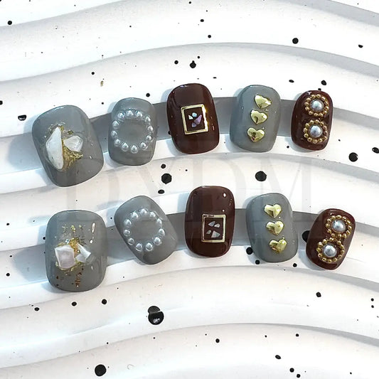 Coffee Fantasy enhance your style with these chic short round nails in gray and brown shades, featuring charming heart-shaped embellishments and delicate pearls