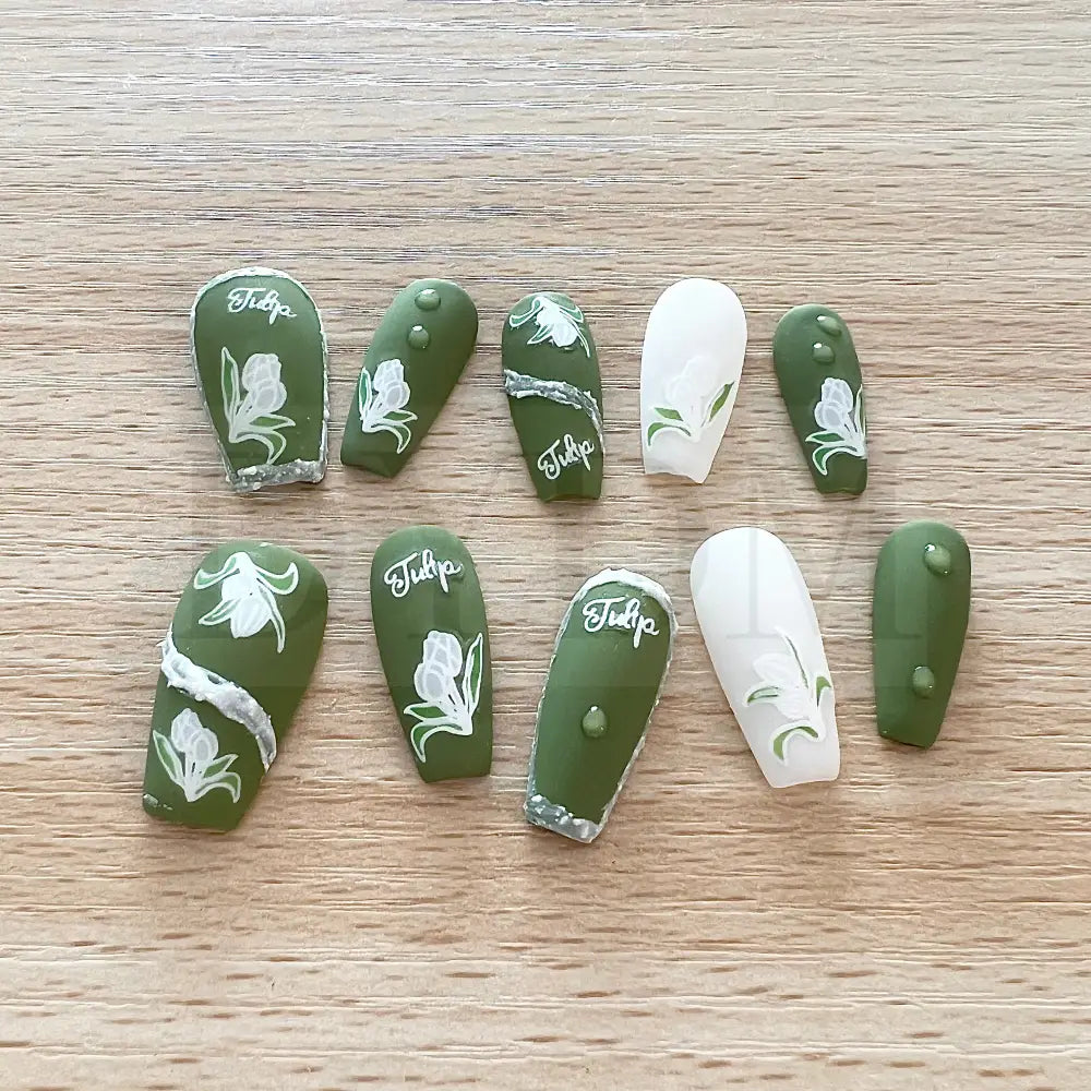 Emerald Elegance These stunning handmade press-on nails showcase a rich emerald color and are adorned with delicate white tulip paintings, adding an exquisite touch of elegance to your manicure.