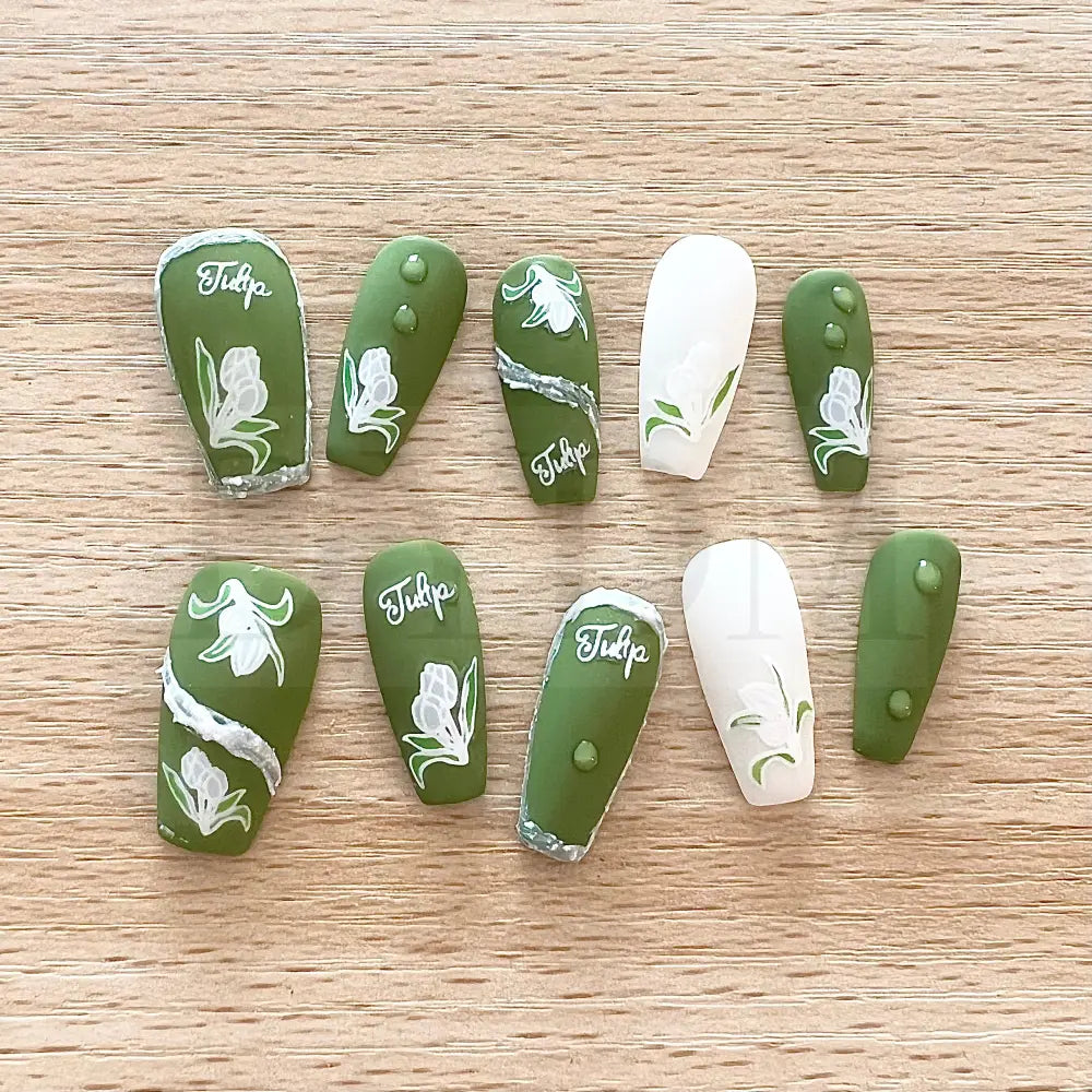 Emerald Elegance These stunning handmade press-on nails showcase a rich emerald color and are adorned with delicate white tulip paintings, adding an exquisite touch of elegance to your manicure.