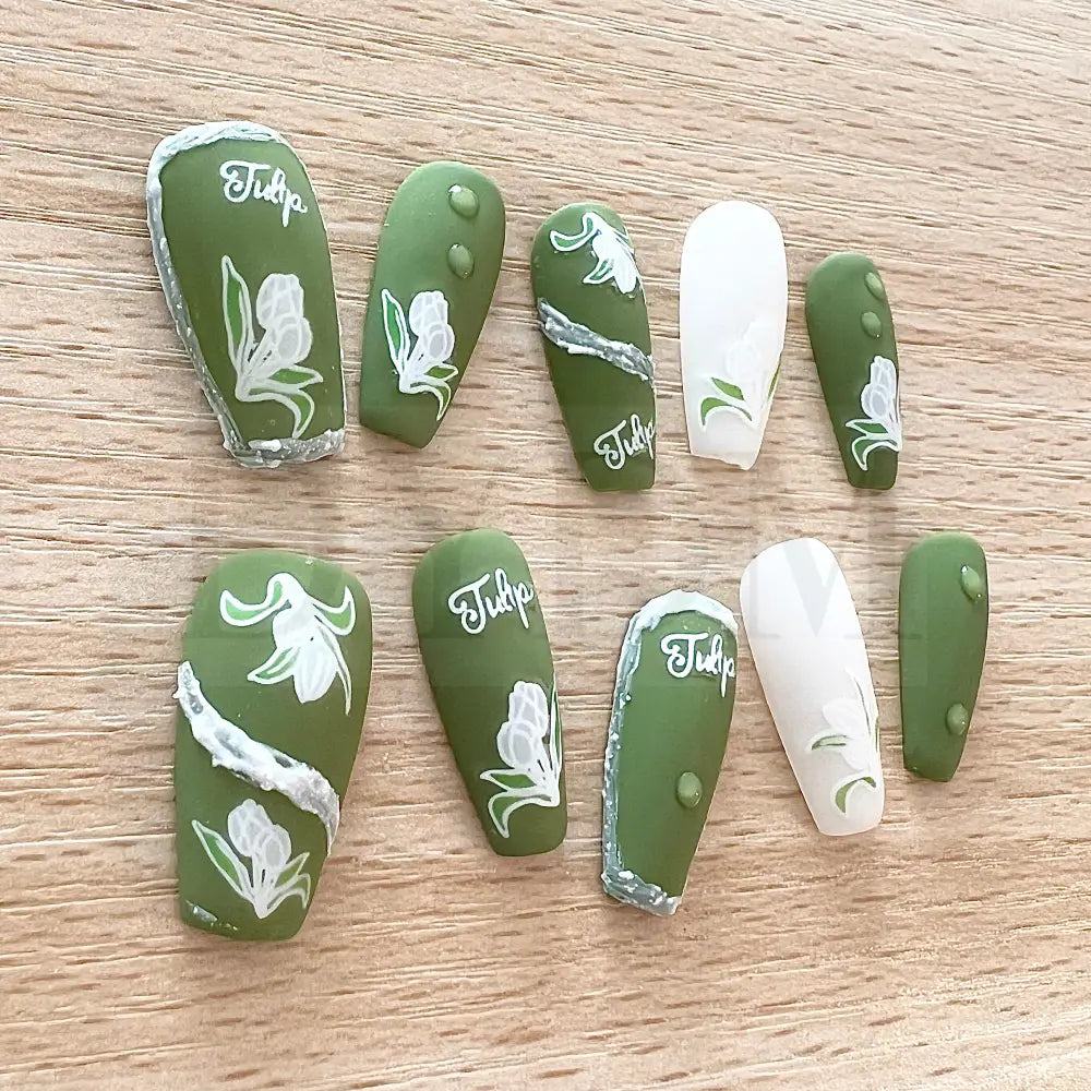 Emerald Elegance These stunning handmade press-on nails showcase a rich emerald color and are adorned with delicate white tulip paintings, adding an exquisite touch of elegance to your manicure.