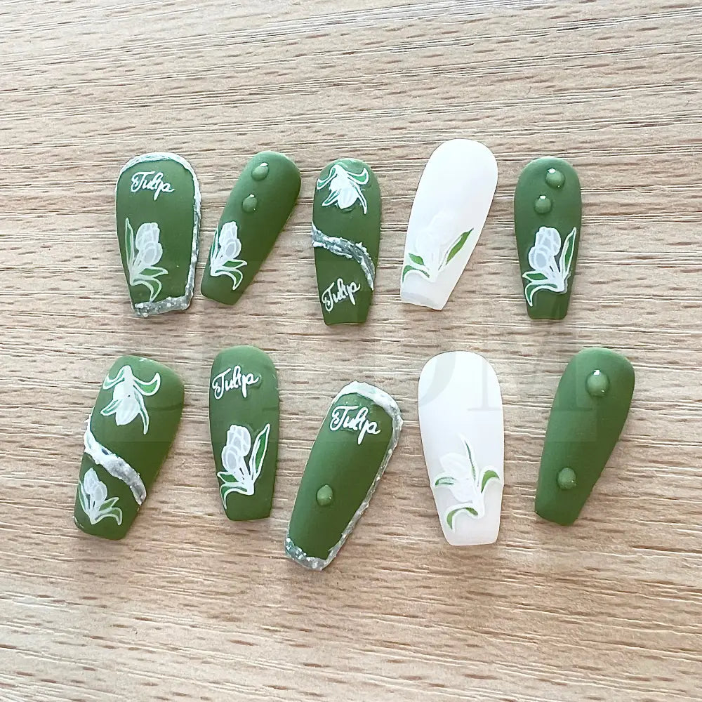 Emerald Elegance These stunning handmade press-on nails showcase a rich emerald color and are adorned with delicate white tulip paintings, adding an exquisite touch of elegance to your manicure.