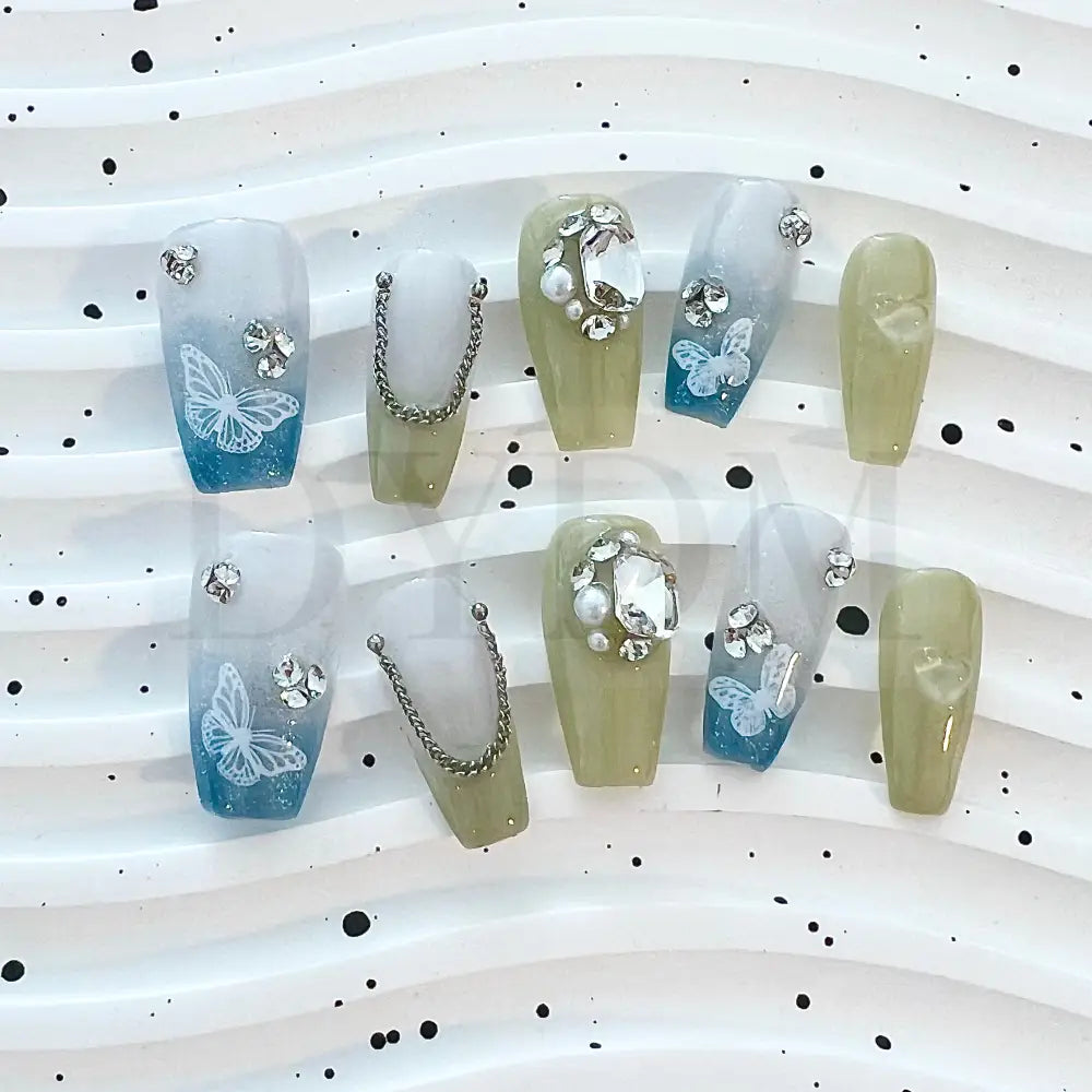 Gradient Chain Jewels  Elevate your look with our elegant press-on nails featuring a blue and green gradient effect, adorned with shimmering gemstones and delicate butterfly designs for a touch of sophisticated beauty.