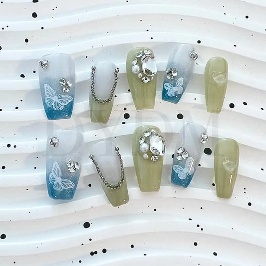 Gradient Chain Jewels  Elevate your look with our elegant press-on nails featuring a blue and green gradient effect, adorned with shimmering gemstones and delicate butterfly designs for a touch of sophisticated beauty.